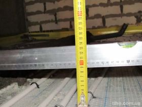 Толщина стяжки в санузлах: уровень по маяку.